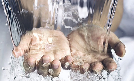 Water cascading over a pair of hands.