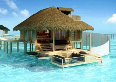 A cottage sits over the turquoise waters at the Beach House at Manafaru, Maldives 