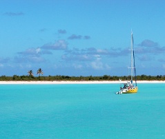 A sailboat cruises the coast off Barbuda, Caribbean