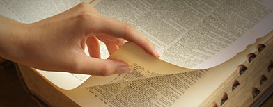 Hand turning page of dictionary. (Getty Images)