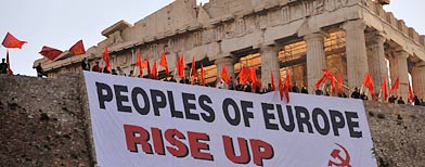 Greek protesters unfurl a banner over the defensive walls of the ancient Acropolis, the country's most famous monument (AP Photo/Nikolas Giakoumidis)