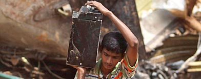 A search operation team member carries a box recovered from the remains of the Air India Express plane that crashed in Mangalore, in the southern Indian state of Karnataka, Sunday, May 23, 2010. Investigators searching for clues as to what caused India's worst air disaster in more than a decade recovered the cockpit voice recorder and flight data recorder Sunday from the charred remains of the flight. (AP Photo/Rafiq Maqbool)