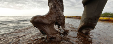 Plaquemines Parish coastal zone director P.J. Hahn lifts his boot out of thick beached oil. (AP Photo/Gerald Herbert)