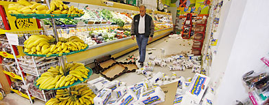 Grocery store manager Jorge Lepoe walks past aisles of fallen goods at his store in downtown Calexico, Calif. Monday, April 5, 2010. .  (AP Photo/Denis Poroy)