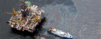 Workboats operate near the Transocean Development Drilling Rig II at the site of the Deepwater Horizon incident in the Gulf of Mexico Friday, July 16, 2010. The wellhead has been capped and BP is continuing to test the integrity of the well before resuming production. (AP Photo/Dave Martin)