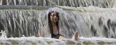 A woman cools down in a fountain during Minsk heat wave. (Reuters/Vladimir Nikolsky)