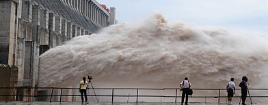 In this photo released by China's Xinhua news agency, journalists take photos as flood water is released from the Three Gorges Dam's floodgates in Yichang, in central China's Hubei province, Tuesday, July 20, 2010. (Xinhua, Cheng Min/AP Photo)