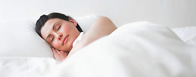 Young woman asleep in bed (Photo by Adam Gault)