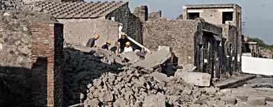 Workers stand among debris in the ancient Roman city of Pompeii, Italy, Saturday, Nov. 6, 2010. (AP Photo/Salvatore Laporta)