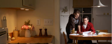 Couple paying bills in kitchen. (Getty Images)