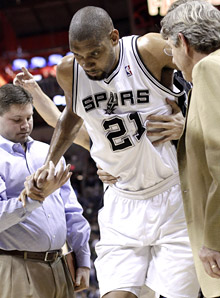 Tim Duncan leaves the court after he sprained his left ankle during the first quarter on Monday against the Warriors.