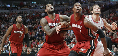 Bulls center Joakim Noah, right, gets boxed out by LeBron James (6) and Chris Bosh (1). At left is Heat guard Dwyane Wade (3).