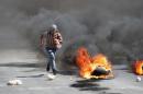 A Palestinian protester runs away from Israeli soldiers during clashes, following a protest against the Israeli military action in Gaza, in the West Bank city of Nablus on Friday, Aug. 22, 2014. (AP Photo/Nasser Ishtayeh)