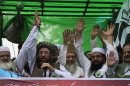 Maulana Samiul Haq, second left, head of a coalition of hardline Islamist religious leaders and politicians 'Defense of Pakistan Council', along with other coalition leaders wave to supporters as they lead a rally, in Lahore, Pakistan, Sunday, July 8, 2012. Prominent hardline Islamists led thousands of people in a protest against Pakistan's decision to allow the U.S. and other NATO countries to resume shipping troop supplies through the country to Afghanistan. (AP Photo/K.M. Chaudary)