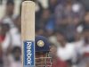 India's captain Dhoni raises his bat to celebrate his half-century on the second day of their second test cricket match against West IndiesÕ in Kolkata