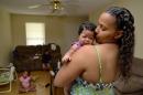In this June 18, 2014 photo, Army Sgt. LaQuisha Gallmon holds her 2-month-old Abbagayl, as her children Dallin, 8, and Angelicah, 5, sit in their home in Greenville, S.C. Gallmon said that her local VA office had authorized her to see a private physician during her pregnancy, so she went to an emergency room after experiencing complications in her sixth month of pregnancy. She said the VA has thus far refused to pay the resulting $700 bill. (AP Photo/ Richard Shiro)