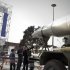 An Iranian family looks at a display of a Shahab-3 missile in Tehran