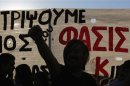 An anti-fascist protester raises his fist during a demonstration in Athens