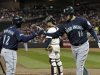 Seattle Mariners' Trayvon Robinson, left, congratulates Alex Liddi after Liddi's solo home run off Minnesota Twins pitcher Liam Hendriks in the sixth inning of a baseball game Tuesday, Sept. 20, 2011 in Minneapolis. (AP Photo/Jim Mone)