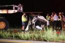 In this photo taken on Thursday, June 26, 2014, rescue personnel and police investigate a deadly two-vehicle crash on U.S. 27 in Nicholasville, Ky. Six people, including three children, are dead and four are injured after the fiery head-on collision in central Kentucky. Nicholasville police patrolman Todd White says a station wagon was traveling northbound when it lost control, crossed the median and collided head-on with a van. (AP Photo/The Lexington Herald-Leader, Mark Cornelison)