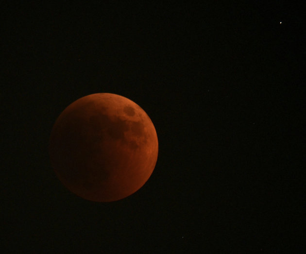 The moon turns red during a total lunar eclipse, as seen from Skopje, Macedonia, on Wednesday, June 15, 2011. (AP Photo/Boris Grdanoski)