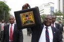 Kenya's Finance Minister Githae displays the briefcase containing his speech as he walks to present the budget to the parliament in Nairobi