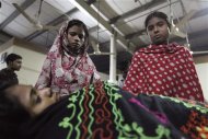 Colleagues stand beside Asma, a garment worker, who was injured in a devastating fire at a garment factory in Savar, outskirts of Dhaka November 24, 2012. REUTERS/Andrew Biraj