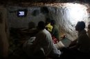 Syrians watch TV at an underground shelter in Al-Bueda, 12 kms from the flashpoint city of Homs