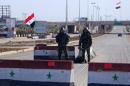 Syrian army soldiers man a checkpoint along a road in Aleppo
