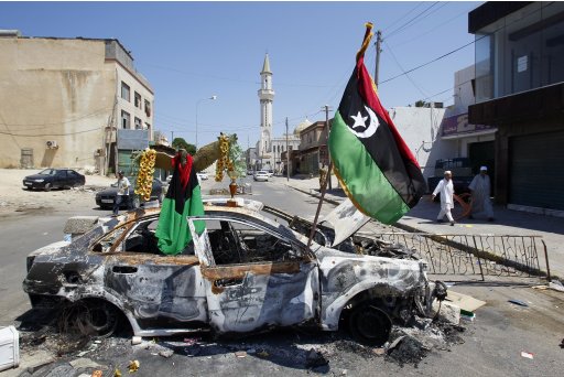 Libya's rebel flag is displayed on a burned car on a check point in Tripoli, Libya, Thursday, Aug. 25, 2011. Libya's rebel leadership has offered a 2 million dollar bounty on Gadhafi's head, but the autocrat has refused to surrender as his 42-year regime crumbles, fleeing to an unknown destination. Speaking to a local television channel Wednesday, apparently by phone, Gadhafi vowed from hiding to fight on quot;until victory or martyrdom.quot; (AP Photo/Francois Mori)
