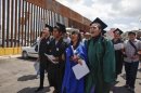 "Dreamers" wearing their school graduation caps and gowns to show their desire to finish school in the U.S., march with linked arms to the U.S. port of entry where they planned to request humanitarian parole, in Nogales, Mexico, Monday, July 22, 2013. U.S. border officials later detained the group who asked to be allowed to re-enter the United States from Mexico on humanitarian grounds in a protest against the country's immigration policies. (AP Photo/Samantha Sais)