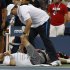 A trainer works on Mardy Fish during his match against Jo-Wilfried Tsonga of France during the U.S. Open tennis tournament in New York, Monday, Sept. 5, 2011. (AP Photo/Mel Evans)