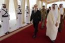 Francois Hollande (centre) is greeted by Qatar's Culture Minister Hamad Bin Abdulaziz Al-Kuwari at Doha airport, on May 4, 2015