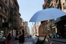A woman walks down the street under a sun umbrella during warm weather on July 6, 2012 in New york City. Forecasts for tomorrow are predicting temperatures near 100 degrees Fahrenheit (38 Celsius) and may feel as hot as 106 because of humidity, according to the National weather Service. Much of the midwest of the United States has been experiencing a severe heat wave which has devastated crops and kept people indoors. (Photo by Spencer Platt/Getty Images)