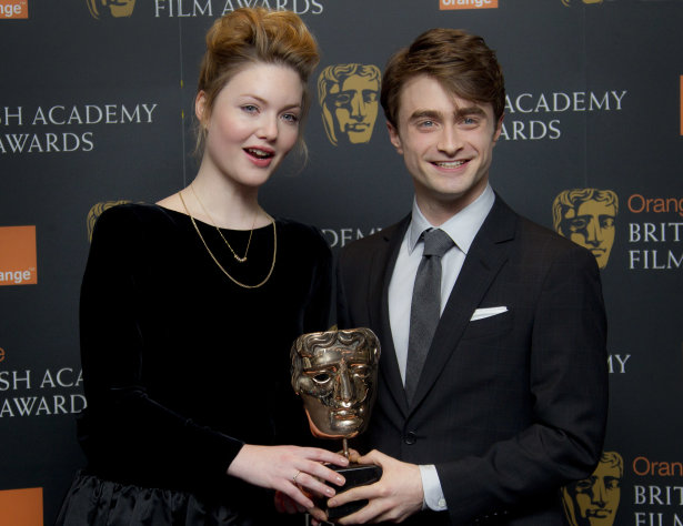 British actors Daniel Radcliffe and Holliday Grainger hold a Bafta Award after they announced the British Academy Film Award nominations in Piccadilly, London, Tuesday, Jan. 17, 2012. (AP Photo/Joel Ryan)