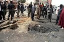 Security officials assess the scene of a bomb blast in Kaduna