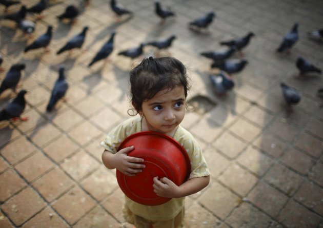 A girl holds a container as …