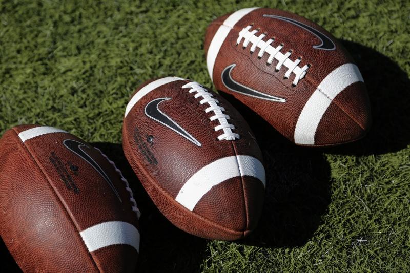 Nike footballs lay on the grass during warm-ups before the start of a college football game between Colorado State and Tulsa Saturday, Oct. 4, 2014, in Ft. Collins, Colo. (AP Photo/Jack Dempsey)