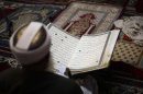 An elderly man reads verses of the Quran, Islam's holy book, on the first day of the fasting month of Ramadan in the grand Mosque in the old city of Sanaa, Yemen, Wednesday, July 10, 2013. Muslims began observing the dawn-to-dusk fast for the month of Ramadan across the Middle East on Wednesday, even as the region is shaken by the crisis in Egypt and the U.N. food agency warned that Syria's civil war has left 7 million people in need of food aid. (AP Photo/Hani Mohammed)