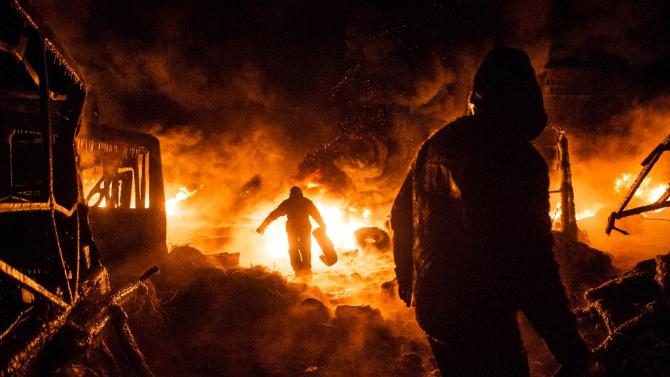 Ukrainian protesters walk past a burning barricade during the 2014 clashes that forced the overthrow of pro-Russian president Viktor Yanukovych