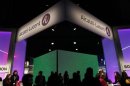 Visitors walk at the Alcatel-Lucent booth at the Mobile World Congress in Barcelona February 28, 2012. REUTERS/Albert Gea