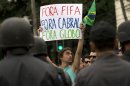 A man holds a sign that reads "FIFA out, Cabral out ( Rio de Janeiro Governor, Sergio Cabral), Globo out ( Brazilian news network O Globo )" as demonstrators march toward the Maracana stadium ahead of the Confederations Cup final in Rio de Janeiro, Brazil, Sunday, June 30, 2013. Protesters have taken to the streets all over Brazil in the past two weeks, calling for a wide-range of reforms. Public approval of Brazilian President Dilma Rousseff's government has suffered a steep drop in the weeks since massive protests broke out across the country, according to Brazil's first nationwide poll released since the unrest began.(AP Photo/Silvia Izquierdo)