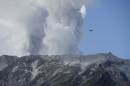 A military helicopter, aiding in rescue operations, flies above Mount Ontake as it continues to erupt, Sunday, Sept. 28, 2014, in Nagano prefecture. Military helicopters plucked several people from the Japanese mountainside Sunday after a spectacular volcanic eruption sent officials scrambling to reach many more injured and stranded on the mountain. Mount Ontake erupted shortly before noon Saturday, catching mountain climbers by surprise and injuring at least 34, including 12 seriously, according to Japan's Fire and Disaster Management Agency. The tally was lower than reported by local officials earlier, but the disaster agency warned that the numbers could still change. (AP Photo/Koji Ueda)