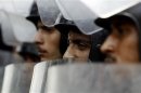 Riot police stand with their shields as members of the Muslim Brotherhood and supporters of ousted Egyptian President Mohamed Mursi protest in front of Egypt's Constitutional Court in Cairo