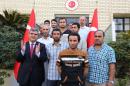 Ankara's ambassador in Baghdad, Faruk Kaymakci (L), stands next to Turkish workers who were kidnapped in Iraq nearly a month ago, in front of Turkey's embassy in the Iraqi capital on September 30, 2015