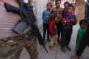 Children surround an Iraqi soldier patrolling the village of Jarif, some 45 kilometres south of Mosul, on November 12, 2016