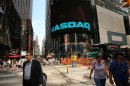 People walk by the Nasdaq stock market on August 23, 2013 in New York City