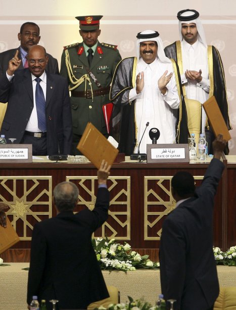 Sudan's President Bashir and Qatar's Emir Sheikh Hamad react as they are shown a peace accord after the signing ceremony in Doha