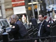 Traders take a break outside the New York Stock Exchange on Wall Street