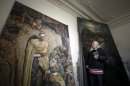 In this pictures taken on Monday, Feb. 27, 2012, Jiri Kuchar, amateur art historian, stands in front of paintings by Franz Eichhorst, left, and Friedrich Wilhelm Kalb, right, in a convent in Doksany, Czech Republic. Kuchar claims he found 16 paintings by German artists in various Czech institutions that Adolf Hitler personally purchased during WWII. (AP Photo/Petr David Josek)